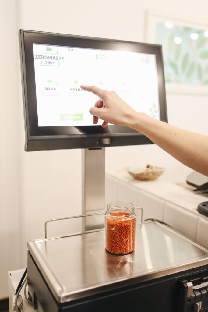A customer uses a touchscreen interface to weigh bulk foods in a zero waste shop.