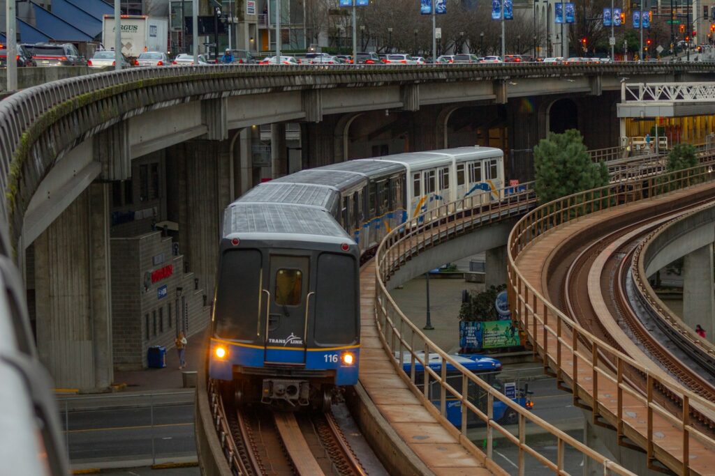 A train traveling down train tracks next to a bridge